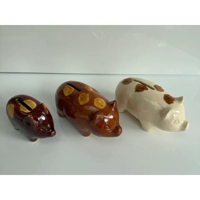 Charming set of American redware spotted pig piggybanks. Perfect for the country kitchen. Two larger are 5.5 x 2.75 x 2.75...
