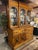 A substantial American Jacobean Revival oak china cabinet and sideboard, circa 1925–1935, executed in richly grained...