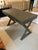 Stylish sleek cerused wood writing desk having a dark grey color and campaign style X motif in the base. Single drawer and...