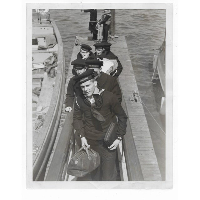 1939 black and white photo of sailors from the "USS Tennessee" disembarking at 79th Street in New York City. Publication...