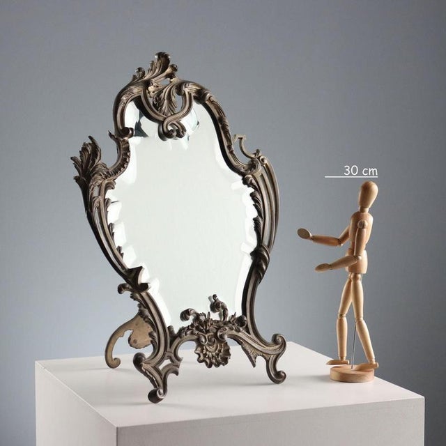 Rococo style bronze table mirror with leaf scroll decorations, plant motifs and shells. This piece is attributed to the...