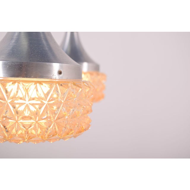 Danish modern double pendant features by aluminium and is suspended by a sculpted piece of solid rosewood. Two lovely...