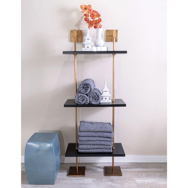 Modern multi-tier shelf in aged brass and black shelves, details urban simplicity with burnished finishes. Marais Shelf...
