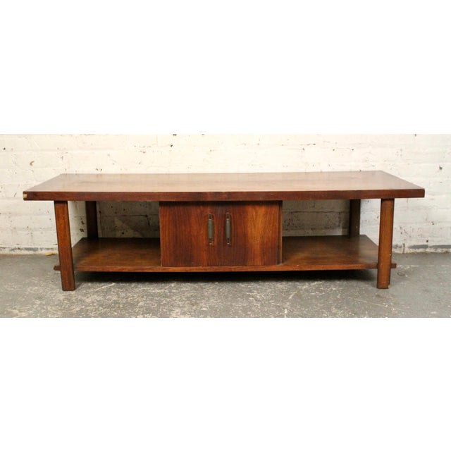 This walnut coffee table is great examples of the strong lines found in mid-century furniture. The piece features two...