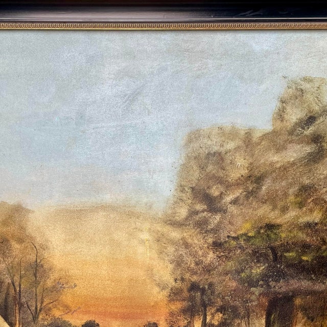 An antique signed landscape painting set in a stunning black wood frame with gold accents. The original F. W. Devoe & Co....