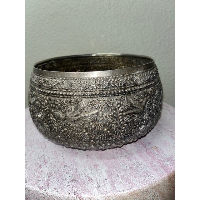 This exquisite Burmese Buddhist offering bowl is a finely crafted work of devotional art, rendered in luminous sterling...