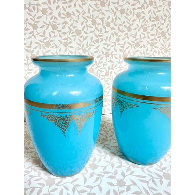 A striking pair of 19th-century blue opaline glass bud vases by Baccarat. Vivid blue glass is finished with gold gilt at...