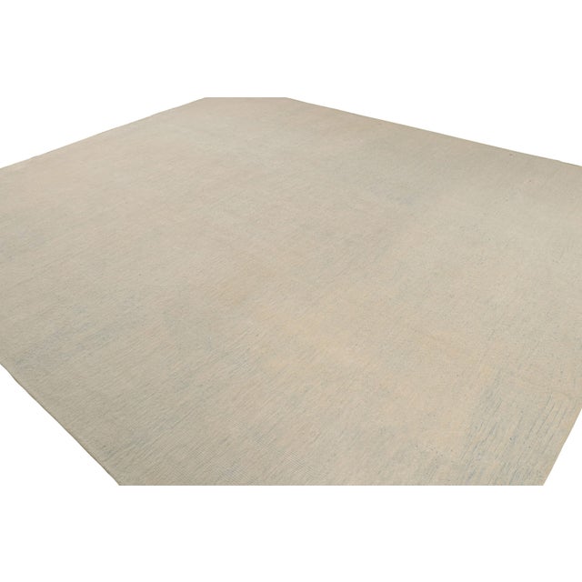 Deriving a thoughtful colourplay of beige, gray and blue from our diverse yarn collection, this 13x15 rug is an artistic...