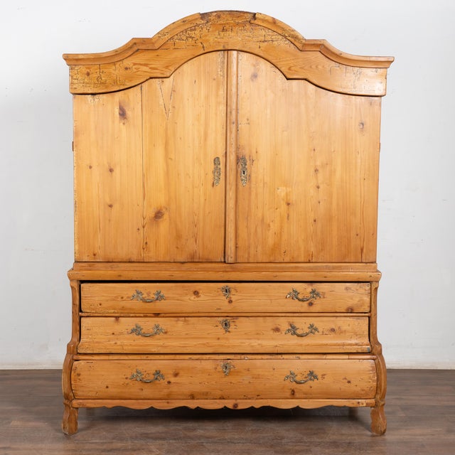 Large pine cabinet with curved bonnet (or crown), two cabinet doors over three large drawers with brass pulls. Built in...