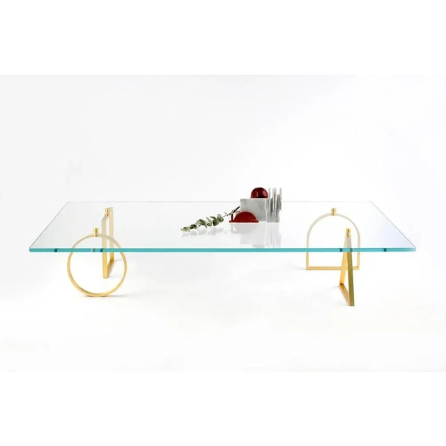 Brass and glass "bagatto" coffee table, ilaria bianchi. Dimensions: h 27 cm x w 150 cm x d 80 cm. Materials: brass, glass....