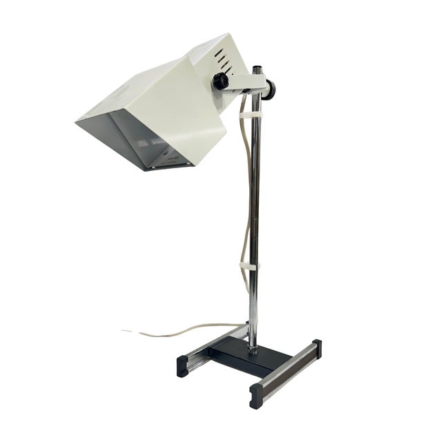 A distinctive vintage adjustable task lamp featuring a sharply angular metal shade mounted on a height-adjustable chrome...