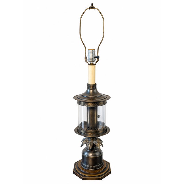 A distinctive vintage Hollywood Regency-style table lamp featuring ornate pineapple-inspired detailing, a warm bronze-tone...