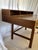 Teak flip-top desk designed by Peter Lovig Nielsen with stamp underneath. Desk has (4) drawers with circular scoop handles...