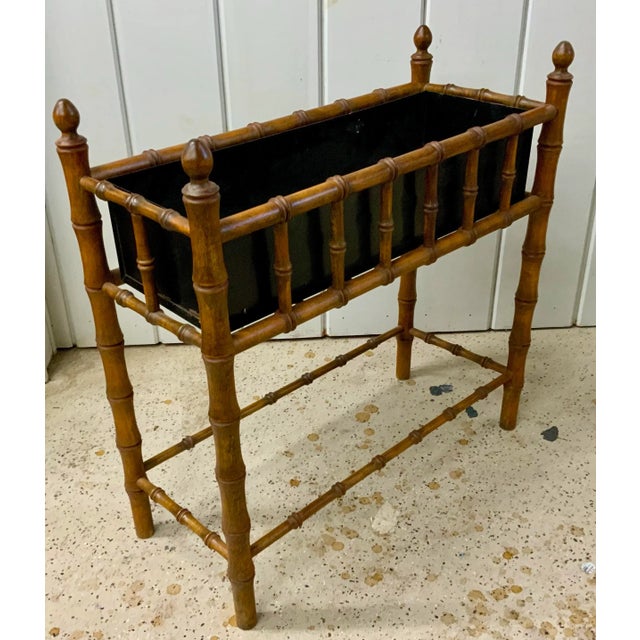 Beautiful faux-bamboo turned planter stand with black painted metal liner .