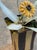 Three tole sunflowers with yellow petals and dark centers on wire stems, with silvered tole leaves, set in a striped...