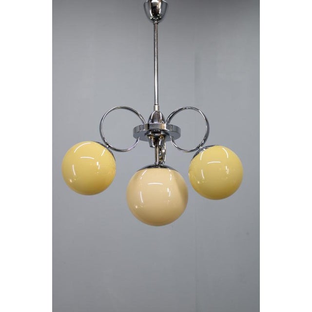 Exceptional art deco chandelier originating from 1930s czechoslovakia, executed in chrome-plated metal with four original...