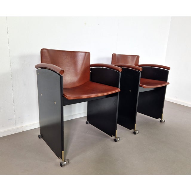 These are pretty rare! A great set of two Arco armchairs on little casters and with cognac leather seats. Almost Italian...