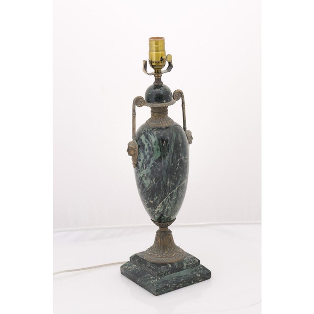 A dramatic pair of verde marble urn lamps accented with bronze-tone mounts and scrolling handles from the Early 20th...