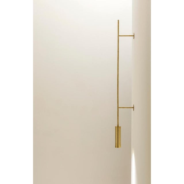 Tf411 wall lamp in satin brass with an orientable tubular diffuser by daluce dimensions: d 16,6 x 10 x h 132 cm....