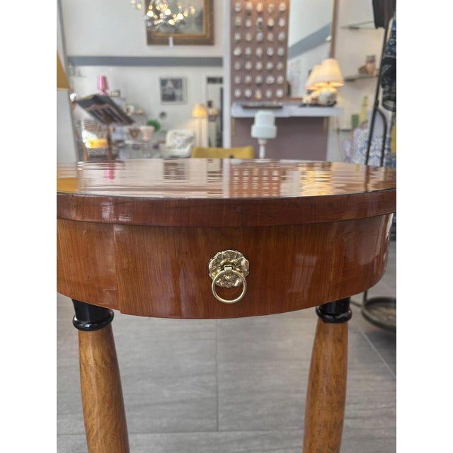 Oval Biedermeier-style table made of cherry wood partially ebonized, one drawer, turned column feet