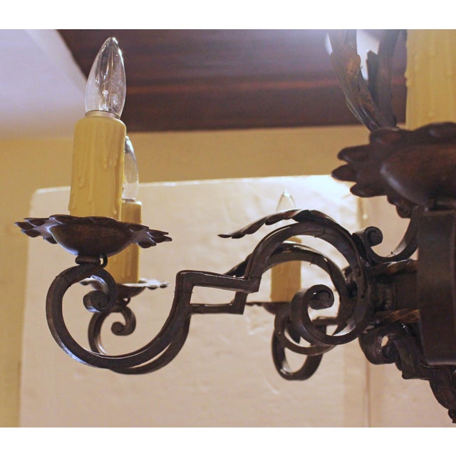 Late 19th century French iron 8-light chandelier. Reddish to verdigris hues with gilt accents. The design with an...