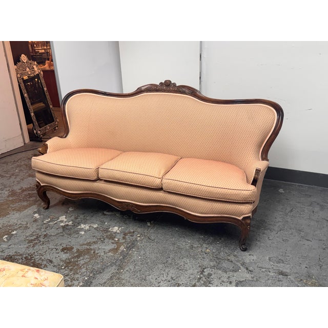 Design Plus Gallery presents a French Louis XV Style Carved Wood Canapé Sofa. The sofa showcases a sculptural serpentine...