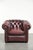 This distinctive English Chesterfield club armchair is made of cowhide leather in a timeless red color. The armchair has a...