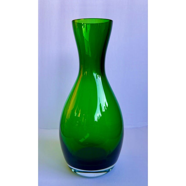 Green Art Glass Vase A striking emerald‑green art glass vase with a beautifully sculpted silhouette. The form transitions...