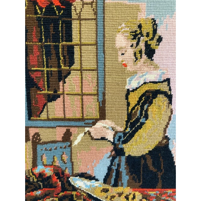 A vintage framed needlepoint artwork inspired by Johannes Vermeer’s “Girl Reading a Letter at an Open Window.” The...