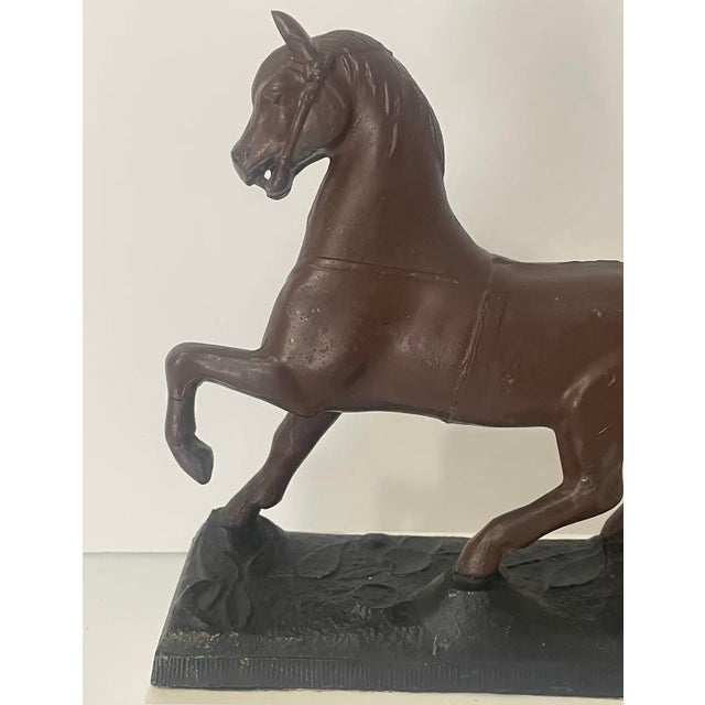 This antique cast metal horse statue dates to the early 20th century and was originally designed as a decorative clock...