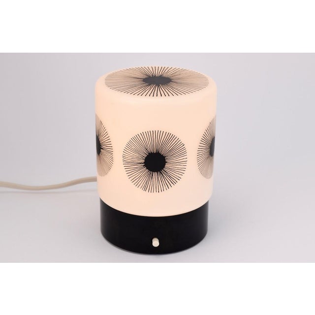 A rare german made table lamp by Erco Leuchten. This lamp has a bakelite base, and a white satined glass lampshade. The...