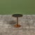 Round side table by Gordon & Jane Martz. The table top is inlaid with black ceramic coin tiles. The frame, base and...