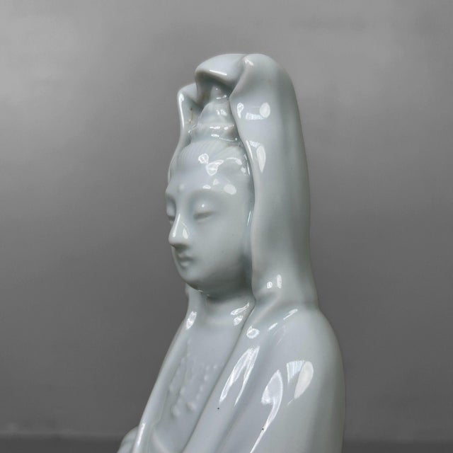A refined Japanese altar figure crafted from glossy white porcelain, with a soft, almost translucent quality. It...