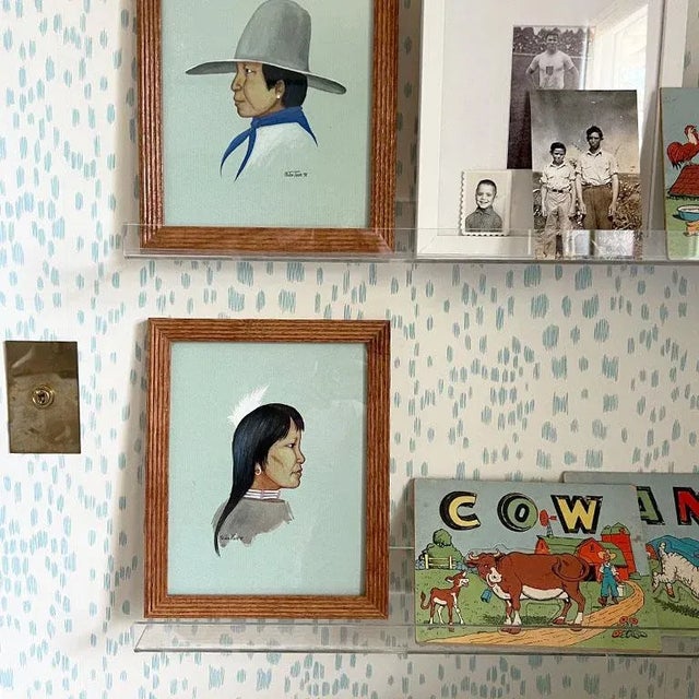 A framed pair of a Native American man in woman. These paintings are by Oklahoma artist Jon Tiger. They were created in...