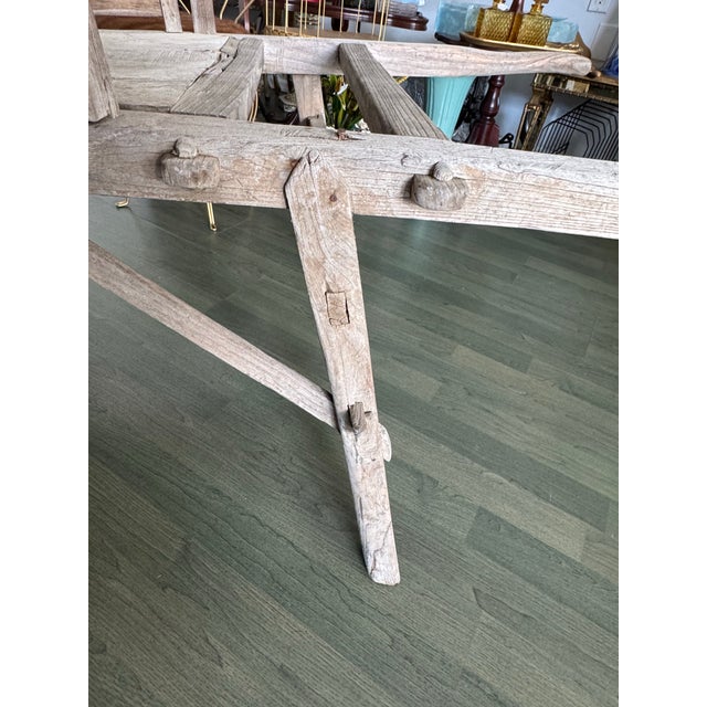 A striking and authentic antique wooden wheelbarrow, hand-carved and crafted using traditional joinery techniques, likely...