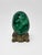 A striking polished solid malachite egg, notable for its substantial weight, deep emerald-green color, and richly figured...