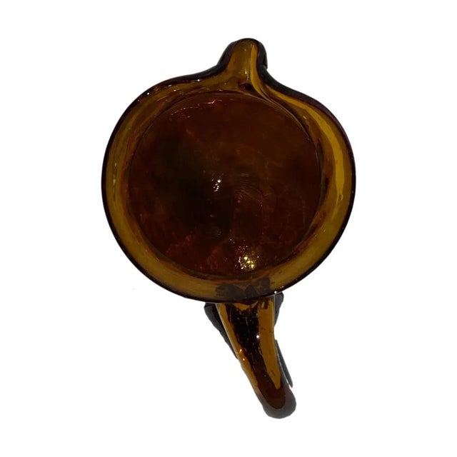 Beautiful hand-blown amber glass pitcher with a twisted ribbed design.