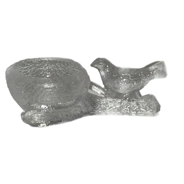 Textured clear crystal salt cellar featuring a bird perched beside a nest on a wishbone shaped tree branch. Likely dating...