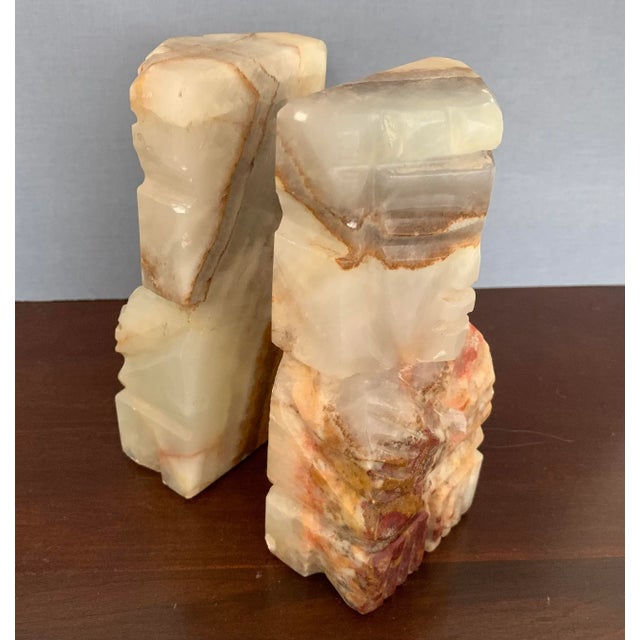 Nicely carved solid stone bookend pair in striated figured onyx or agate, midcentury circa 1970s. The pair depict Mexican...