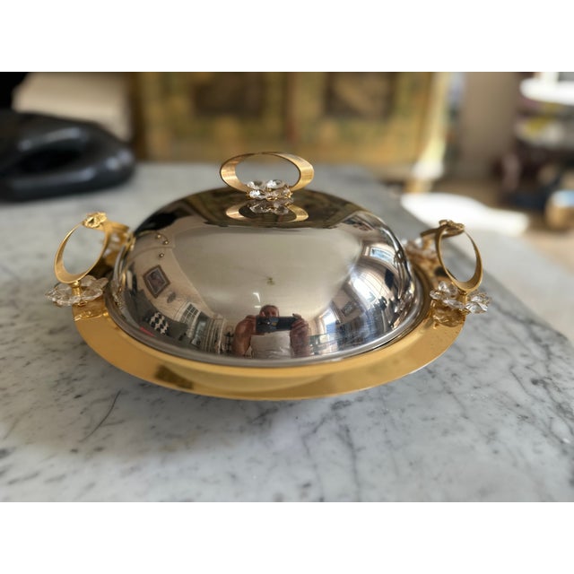 This striking Italian serving dish dates from the 1970s and combines polished stainless steel with gold-tone metal and...