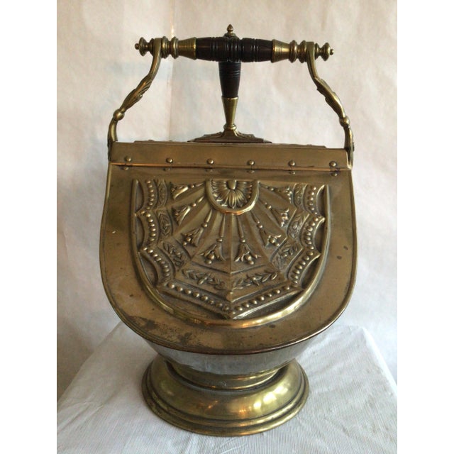 1900s English Brass Coal Scuttle with Shovel Accented with embossed detailing Hinged lid Turned wood handle Some small...