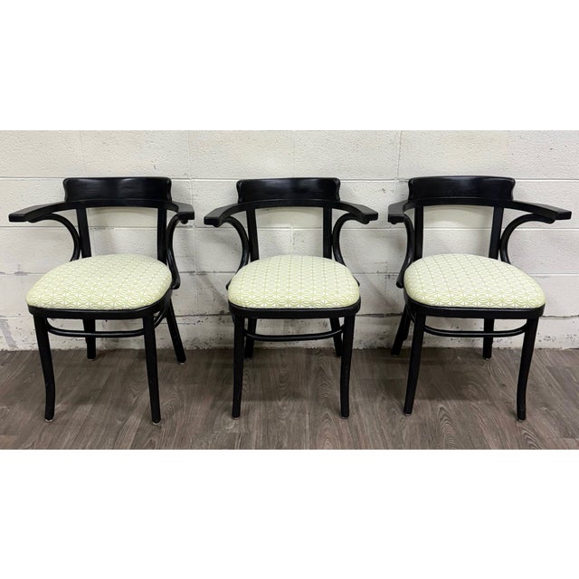 This is a stylish set of three vintage bentwood arm chairs featuring gracefully curved frames finished in black with newly...