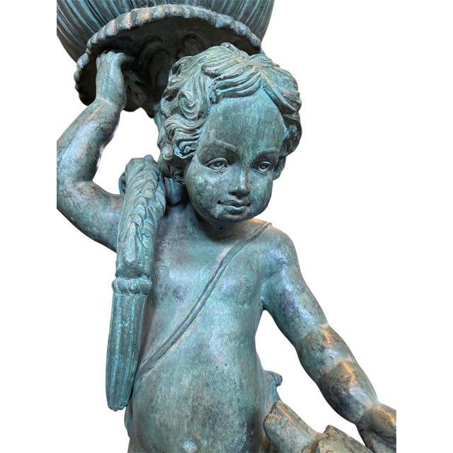 An elegant pair of planters depicting cherubs with animals, crafted from green patinated cast bronze, typical of...