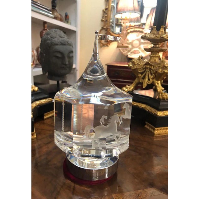 A 1985 Peter Aldridge design Steuben carousel depicting a group of three carousel horses rotating around a center axis....