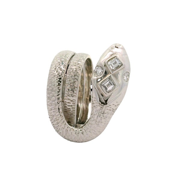 A contemporary platinum ring designed in a striking serpent motif, featuring round-square white diamonds totaling 0.35...