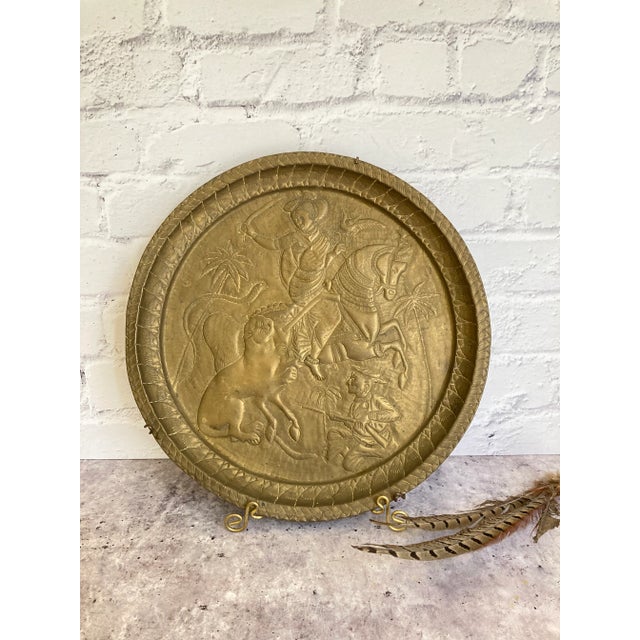 Beautiful gold tone metal wall tray/plate in a relief, or repoussé style. The subject matter is two figures, one on a...