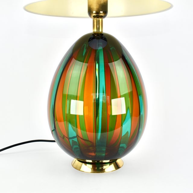 A striking vintage Murano glass table lamp by VeArt, featuring rich green, red striped glass with elegant brass accents....