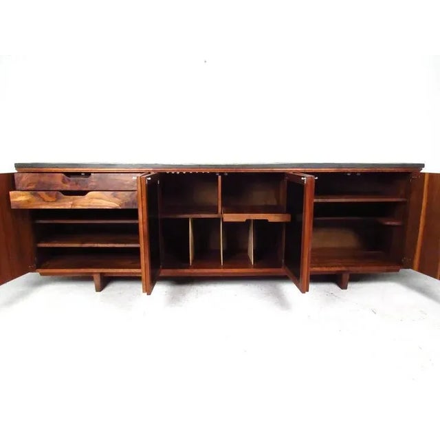 This beautiful sideboard features a striking slate top, unique Brutalist style cabinet doors and a variety of storage...