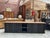 Handcrafted sideboard. It features a raw wood top and a black-patinated body. It has 2 doors opening onto a shelf, 2...