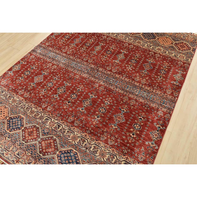 A tribal Khorjin rug hand-knotted with fine wool on a cotton foundation. This oriental rug features geometric botanical...